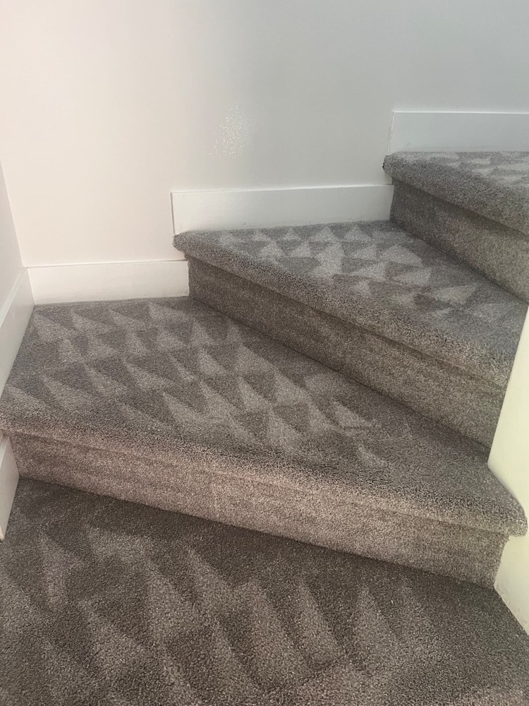 Carpeted stairs professionally cleaned in Kelowna showing fresh grooming marks